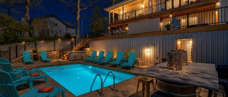 A two-story building with a pool, outdoor seating, and a bar area.