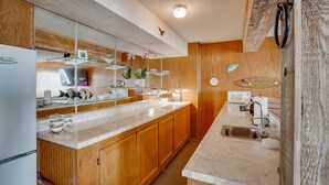 A compact kitchen with wooden cabinets, a marble countertop, a microwave, and a sink. - Private pool vacation home, spa, game rooms, HOA boat slip. (Lake Ozark)