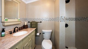 Un baño con lavamanos, espejo e inodoro.
