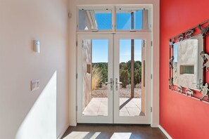 A double glass door entrance with a view of a patio and trees.