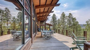 Une terrasse en bois avec des sièges extérieurs et une structure vitrée.
