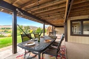 Eine Terrasse im Freien mit Esstisch, mit Blick auf eine malerische Landschaft.