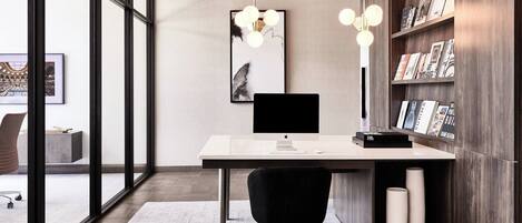 A modern office space with a desk, chair, and bookshelf.