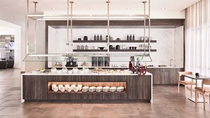 A modern kitchen with a central island, built-in shelves, and a glass-fronted buffet area. - AC Hotel by Marriott Columbus Downtown (Columbus)