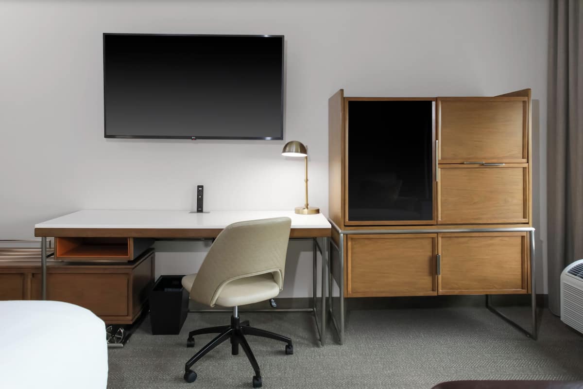 Escritorio, cortinas blackout y tabla de planchar con plancha