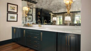 A modern kitchen with dark cabinetry, a large marble countertop, and pendant lighting. - Courtyard by Marriott Thomasville Downtown (Thomasville)