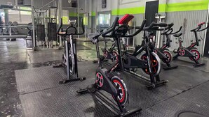 A gym with stationary bikes, weight machines, and a mirrored wall.