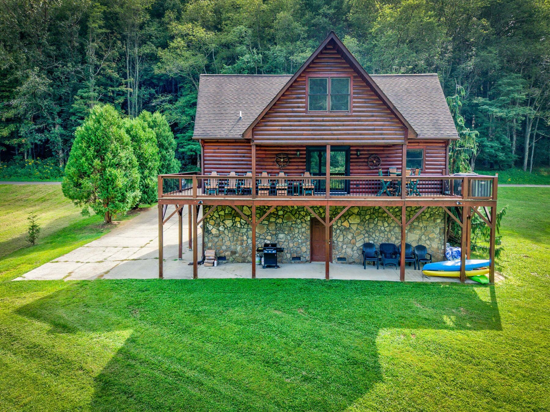 A log cabin with a covered deck and outdoor seating area.