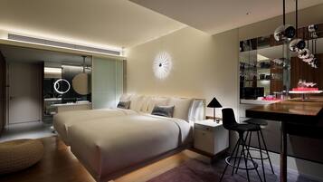 A modern bedroom with a large bed, bedside tables, a desk with a chair, a round wall clock, and a mirror with decorative elements.