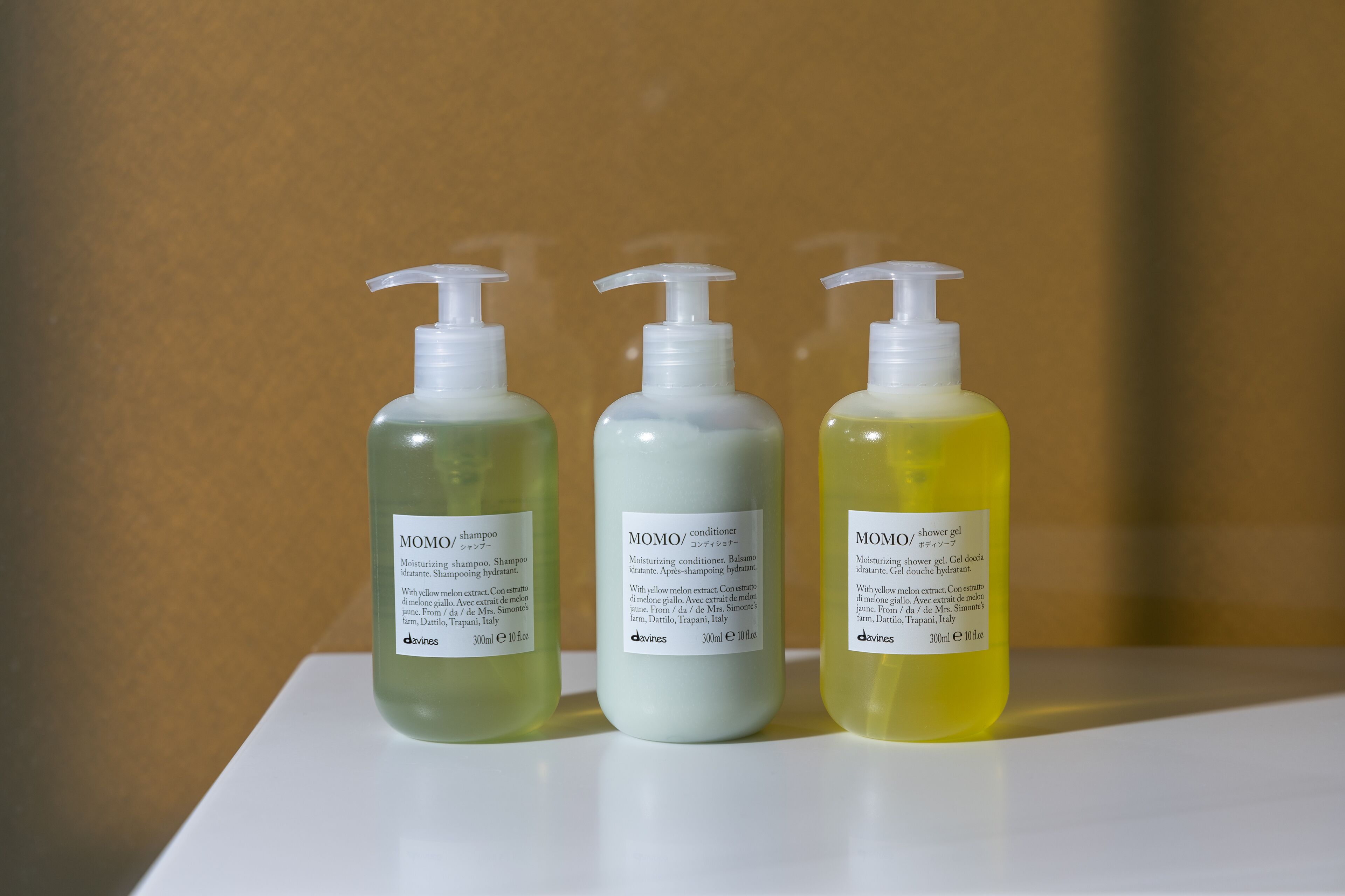 Three bottles of Momo conditioner on a white surface.