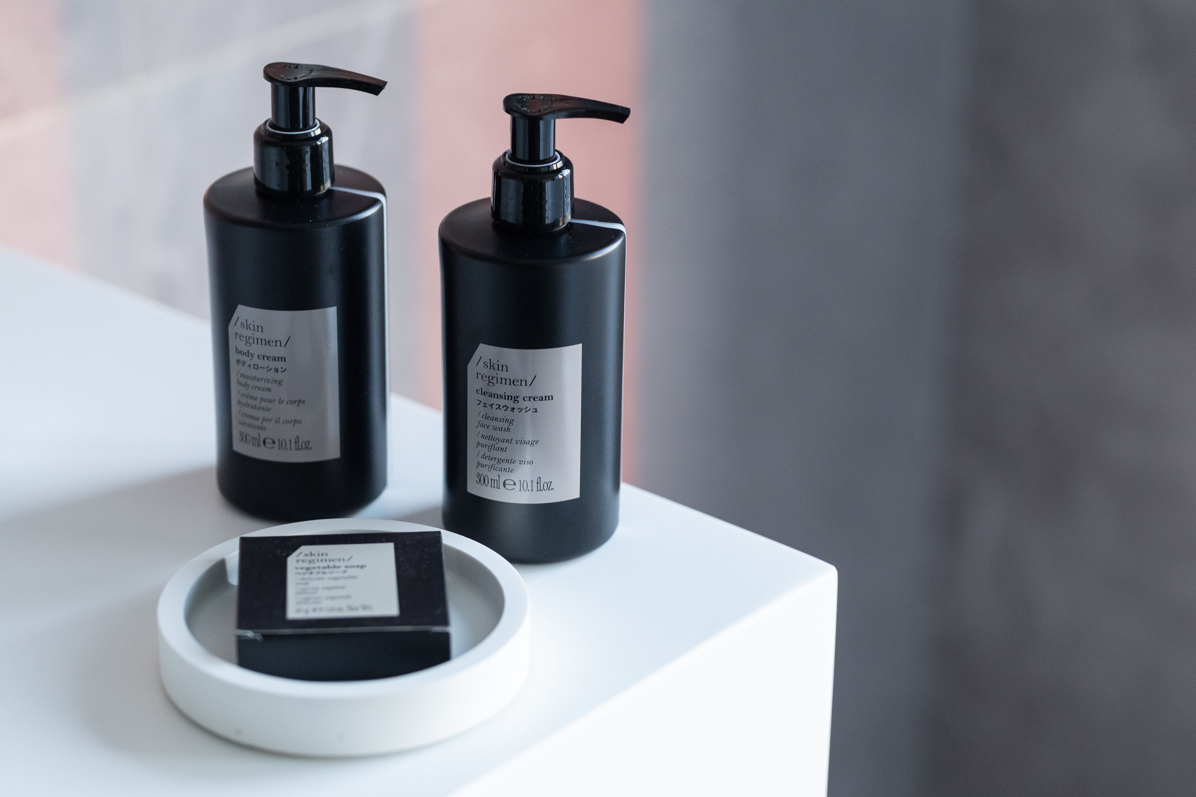 Two black bottles of skincare products on a white surface.