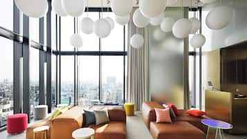 A modern living room with large windows, a city view, and contemporary furniture.