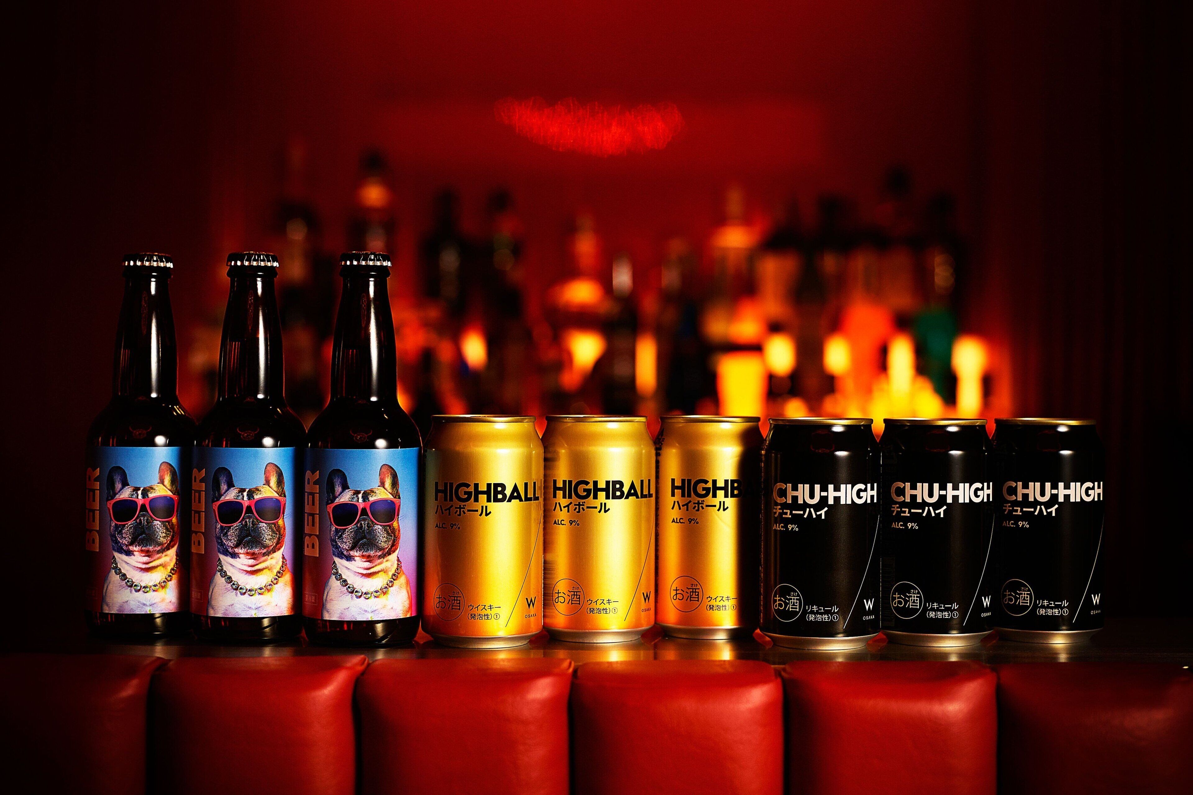Bottles and cans of beer with labels featuring a dog and the text "HIGHBALL" and "CHU-HIGH" on a bar counter.