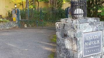 Uma entrada gradeada com uma placa que diz 'ESTATE MAFOLIE PRIVATE'.