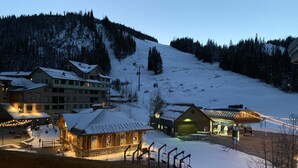 Ein schneebedecktes Bergresort mit Gebäuden, einer Seilbahn und einer Gondel.
