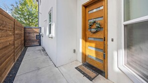 A modern building with a wooden door, a small porch, and a wooden fence. - Modern Biz-Friendly Duplex mins to DT/Convention Center W/Ping Pong & More! (Dallas)