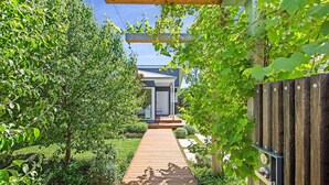 A wooden pathway leading to a modern house with a white door and a small porch. - Resort style home, Pool & Tennis court, walk to Beach & Village (sleeps 10) (Blairgowrie)