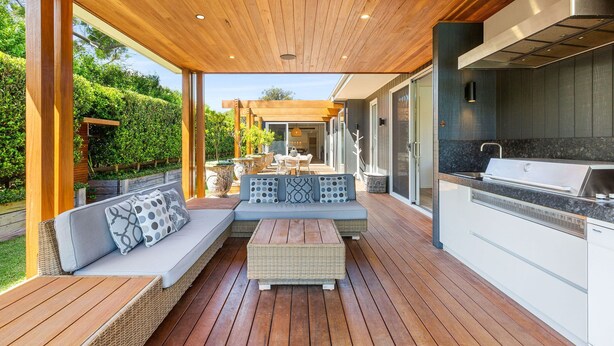 An outdoor deck with a wooden ceiling, a built-in grill, and a seating area with cushions. - Resort style home, Pool & Tennis court, walk to Beach & Village (sleeps 10) (Blairgowrie)