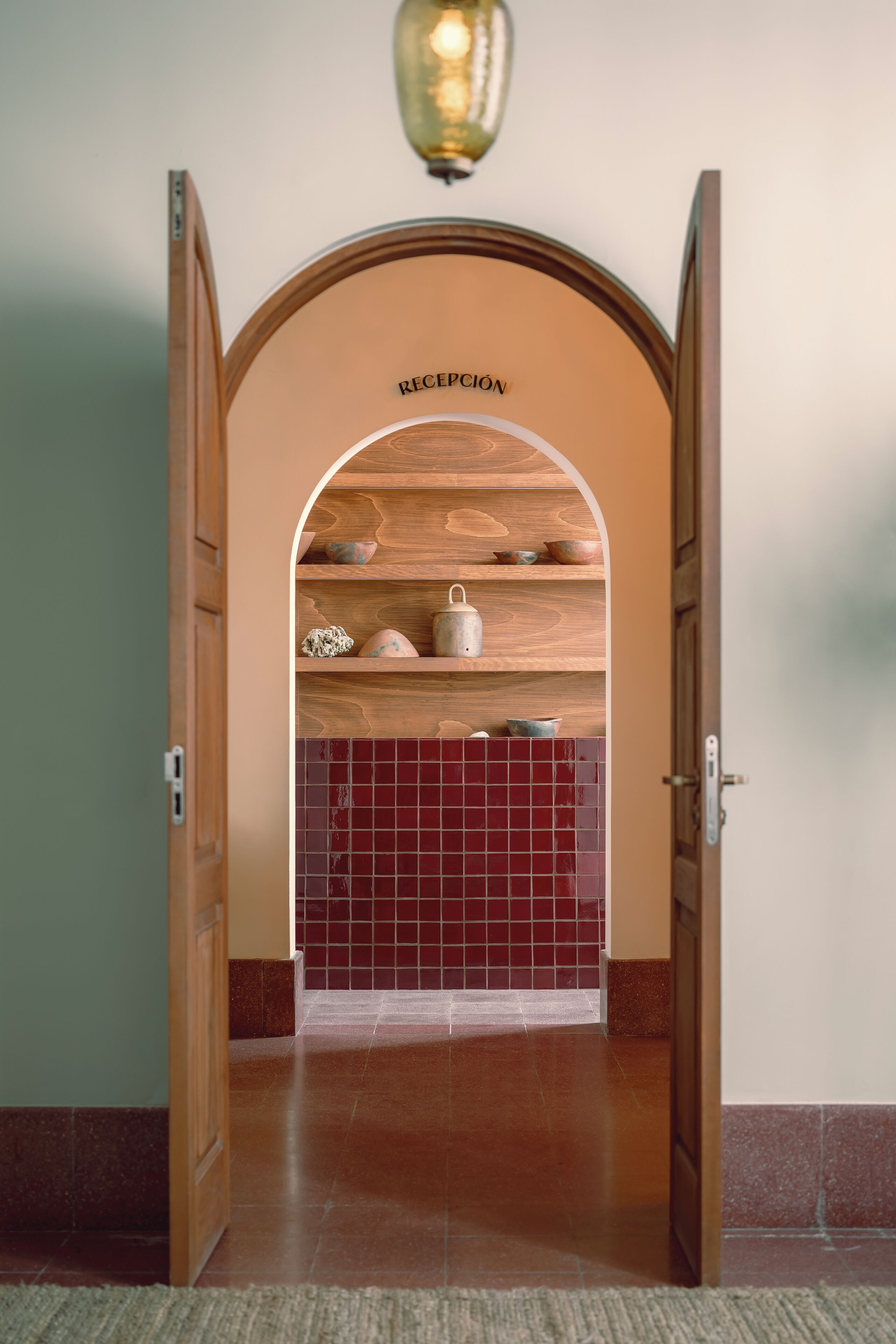 An open doorway leading to a reception area with a wooden shelf displaying various items.