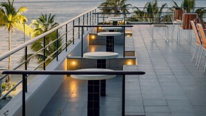 A rooftop terrace with a view of the sea, featuring outdoor seating and palm trees. - Baja Club Hotel, La Paz, Baja California Sur, a Member of Design Hotels (La Paz)