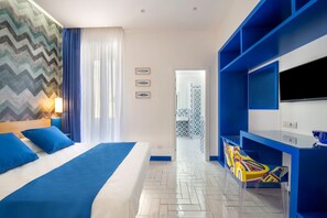 Een moderne hotelkamer met een groot bed, een televisie en een bureau.