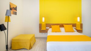 Ein Hotelzimmer mit einem Bett, einem Nachttisch, einer Lampe und einem Bild an der Wand.