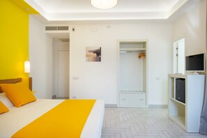 A hotel room with a bed, a wardrobe, a television, and a shower area. - Romantic&Elegant Suite in Sorrento Old Town (Sorrento)