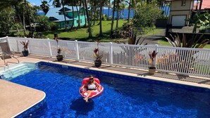 A swimming pool with a person in a red inflatable ring.