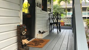 En veranda med en træbænk og en dørmåtte.