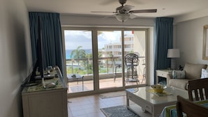 A hotel room with a balcony, a ceiling fan, a dining table, and a sofa. - Maho Royal Islander, La Terrasse 2br 2ba Beautiful White Sand Beach (Lowlands)