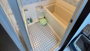 A shower area with a bathtub, a toilet, and a showerhead. - Gojo sefi-apartment 101 (Kyoto)
