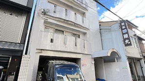 A building with a tiled facade and a parked van in front. - Gojo sefi-apartment 101 (Kyoto)