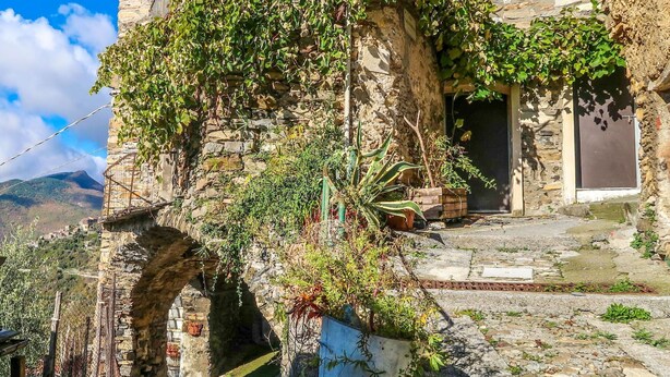 A stone building with a rustic charm, featuring an archway and a wooden door. - Stunning  villa for 6 guests with WIFI and TV (Molini Di Triora)