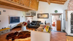 A cozy living room with a fireplace, a television, and a rustic ceiling. - Stunning  villa for 6 guests with WIFI and TV (Molini Di Triora)