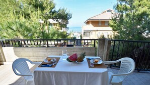 A table set outdoors with a view of the sea and buildings in the background. - Nice apartment for 3 people with WIFI, TV, terrace and pets allowed (Silvi)