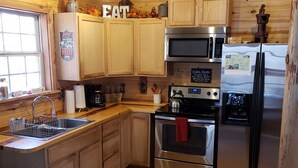 A kitchen with wooden cabinets, stainless steel appliances, and a window.