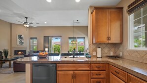 Una cocina moderna con armarios de madera, una isla grande y un lavavajillas empotrado.