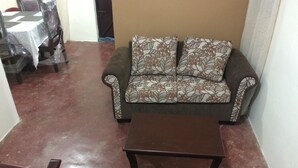 A living room with a sofa, two armchairs, and a coffee table.