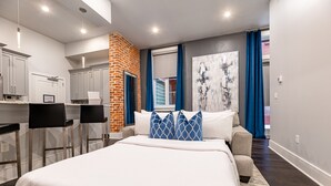 A modern hotel room with a large bed, a kitchen area, and a view of the outside. - ⚜️ Perfect Downtown 1 Bedroom plus Queen Sleeper Sofa & Private Terrace ⚜️ - The Livingston (New Orleans)