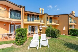 A multi-story hotel with balconies, outdoor seating, and a well-maintained lawn. - Albarella S3 1, Isola di Albarella, Italy (Isola di Albarella)