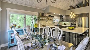 Cocina moderna con una isla central, electrodomésticos integrados y un comedor con un ventanal amplio.