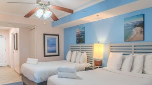 A hotel room with two beds, a ceiling fan, a framed picture, and a lamp. - Towers On the Grove 724 (North Myrtle Beach)