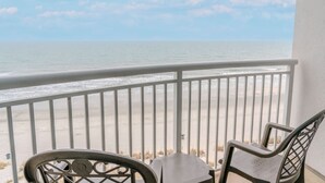 A balcony with a view of the ocean, a metal chair, and a small table. - Towers On the Grove 724 (North Myrtle Beach)