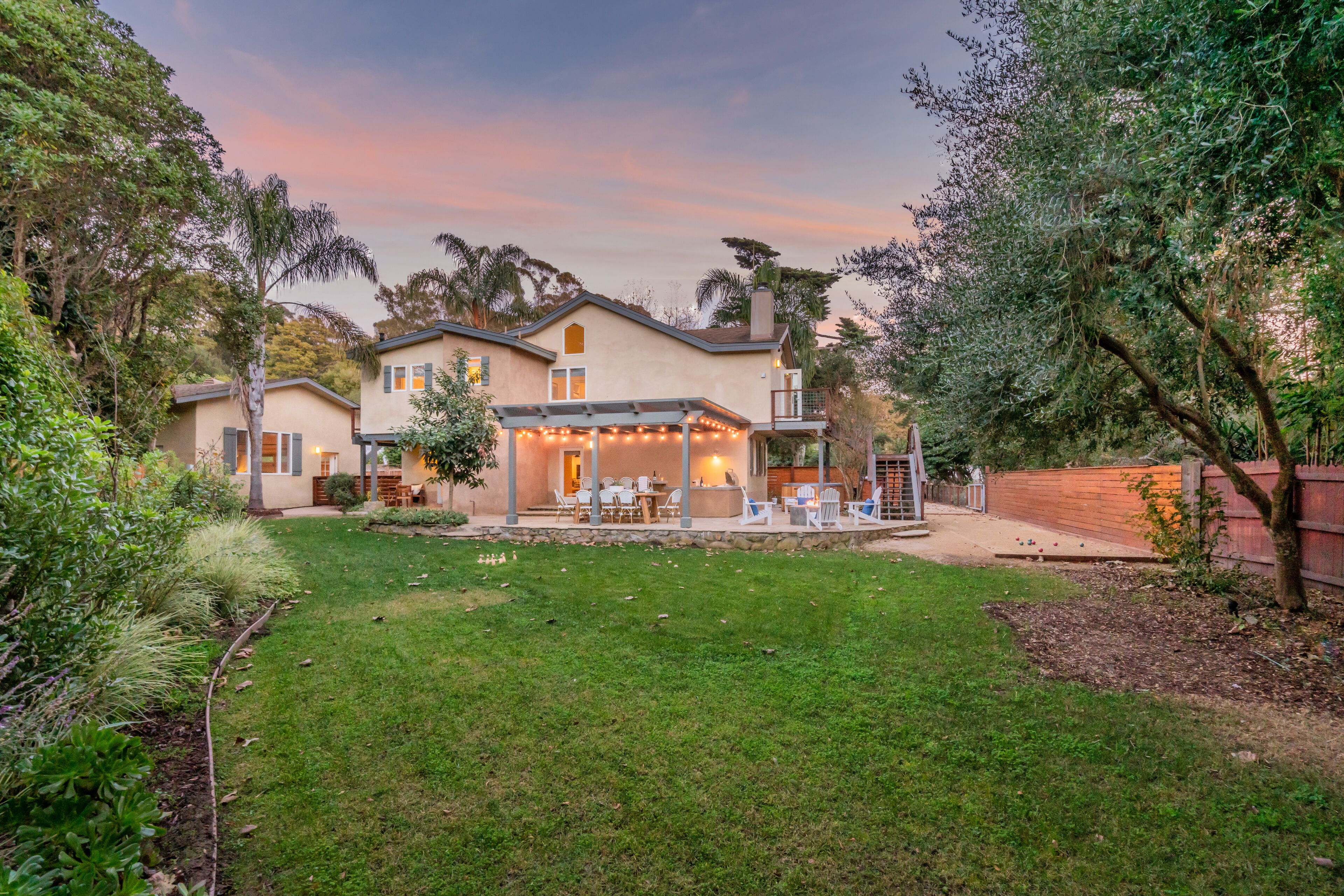 A two-story house with a covered patio and outdoor seating area.