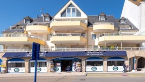 A multi-story building with balconies, storefronts labeled "Biscuiterie de Quiberon" and "Atelier de fabrication". - Le Hoche by Interhome (Quiberon)