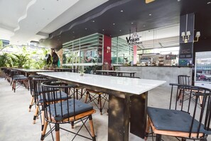 A vegan restaurant with a long counter and black chairs. - Ibooking Trams Square Chiang Mai (Chiang Mai)