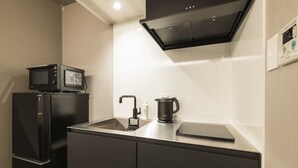 A modern kitchen with a built-in microwave, a coffee maker, and a tablet on the counter. - GRAND BASE Kagoshima Tenmonkan (Kagoshima)