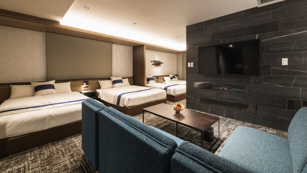 A hotel room with two beds, a TV, a fireplace, and a sofa. - GRAND BASE Kagoshima Tenmonkan (Kagoshima)