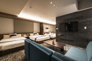 A hotel room with two beds, a TV, a fireplace, and a sofa. - GRAND BASE Kagoshima Tenmonkan (Kagoshima)