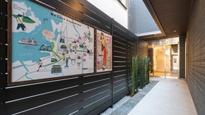 A corridor with a map and posters on the wall, leading to a building entrance. - GRAND BASE Kagoshima Tenmonkan (Kagoshima)